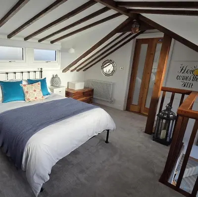 a bedroom with a large bed with blue pillows at The Old Stables in Felixstowe