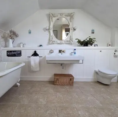 a bathroom with a sink and a toilet and a mirror at The Old Stables in Felixstowe