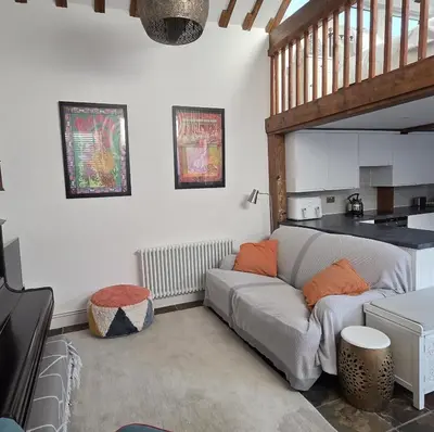 a living room with a couch and a table at The Old Stables in Felixstowe