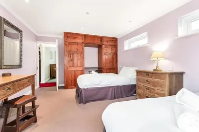 a bedroom with two beds and a desk and a mirror at 2-Bed Home with Free Parking - 2 min Walk to Bus in Cherry Hinton