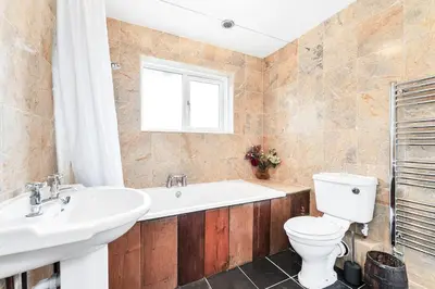 a bathroom with a tub and a toilet and a sink at 2-Bed Home with Free Parking - 2 min Walk to Bus in Cherry Hinton