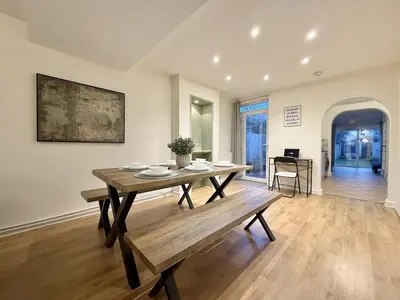 a dining room with a wooden table and a bench at 2 bed house secure parking Sleeps 6 in Ipswich