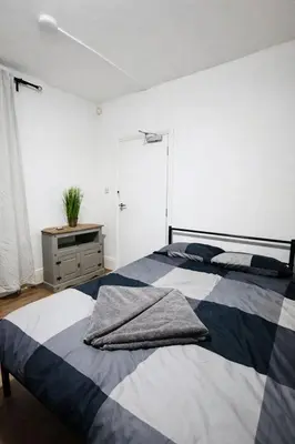 a bedroom with a bed with two pillows on it at landvue stays, The Colchester town White House 4 bed 2 bath! in Mundon