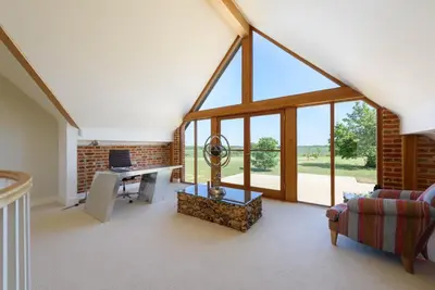 an attic living room with a desk and windows at Fidlers Moat - Games Room, Gym, Hot Tub