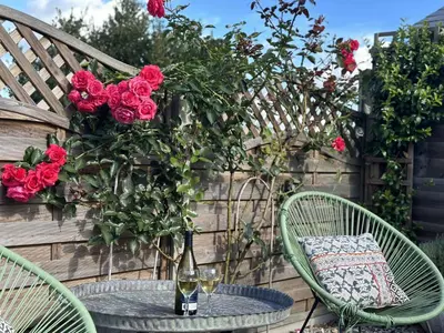 a table with a bottle of wine and two chairs at 4 Angel Lane in Woodbridge
