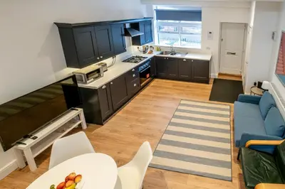 a kitchen with black cabinets and a blue couch at 1 Volunteer House, Leiston, near Sizewell - Ideal for a short or long term corporate lets - Managed by Aldeburgh Coastal Cottages in Leiston