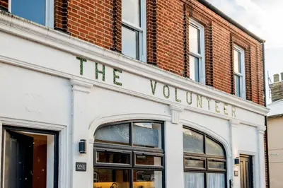 a white building with a sign that reads the volunteer at 1 Volunteer House, Leiston, near Sizewell - Ideal for a short or long term corporate lets - Managed by Aldeburgh Coastal Cottages in Leiston