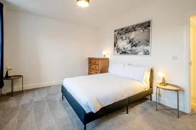 a bedroom with a bed and two side tables at 1 Volunteer House, Leiston, near Sizewell - Ideal for a short or long term corporate lets - Managed by Aldeburgh Coastal Cottages in Leiston