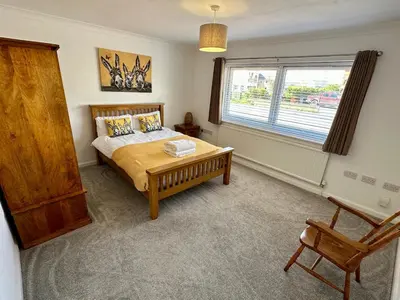 a bedroom with a bed and a window and a chair at Detached, 4 Double Rooms, 2 En-Suites, 5 Car Parking in Lexden