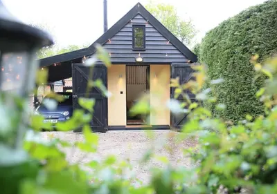 a small house with a door in a yard at Gazebo Lodge in Martlesham