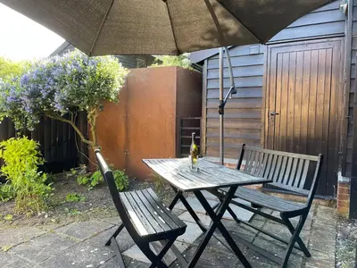 a picnic table and two chairs with an umbrella at Gazebo Lodge in Martlesham