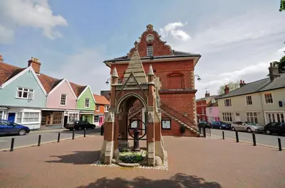 a small brick building with a clock tower on a street at Gazebo Lodge in Martlesham