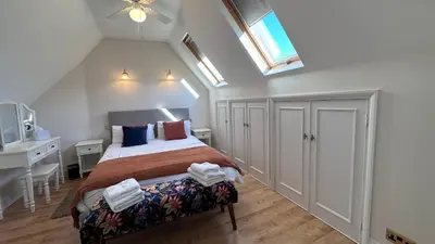 a bedroom with a bed and a desk and a window at The Coach House WPH, Epping in Epping