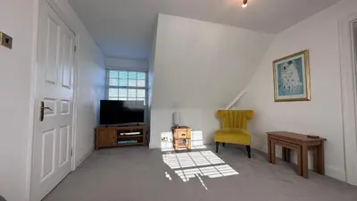 a living room with a television and a chair at The Coach House WPH, Epping in Epping