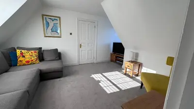 a living room with a couch and a tv at The Coach House WPH, Epping in Epping