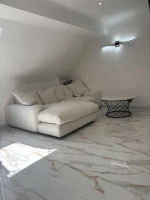 a white couch in a white room with a table at Lavish The White Apartment in Bury Saint Edmunds
