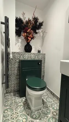 a bathroom with a toilet with a green seat at Lavish The White Apartment in Bury Saint Edmunds