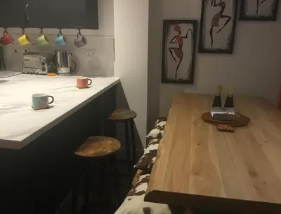 a kitchen with a wooden counter with a table and stools at Norwich New 3 Bedroom Townhouse Close to NNUH UEA