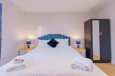 a bedroom with a large bed with towels on it at Hamlet Hideaway Sleeps 14 Off Street Parking - Pass the Keys in Westcliff On Sea