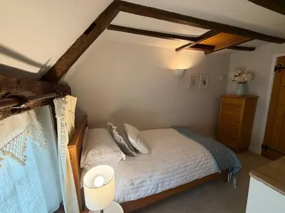 a small bedroom with a bed and a dresser at Pretty Cottage in Harleston, Norfolk, dog friendly in Harleston