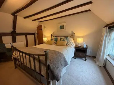 a bedroom with a large bed with pillows on it at Pretty Cottage in Harleston, Norfolk, dog friendly in Harleston