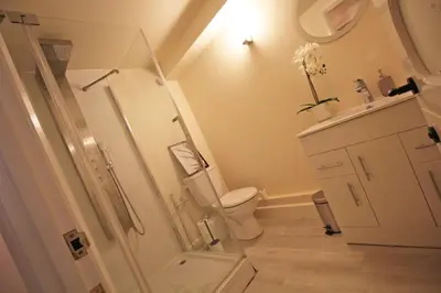 a white bathroom with a toilet and a sink at Central 3 BR Home with Private Courtyard in Ely