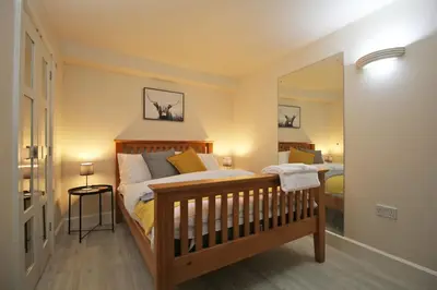 a bedroom with a bed and a large mirror at Central 3 BR Home with Private Courtyard in Ely