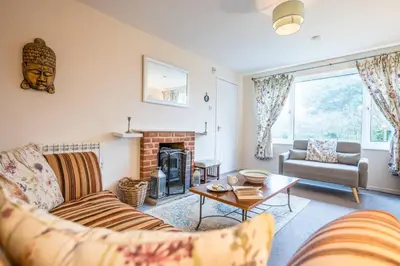 a living room with a couch and a fireplace at 1 Hall Farm Cottage, Aldeburgh in Aldeburgh