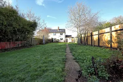 a yard with a fence and a house at The Opulent Property Project Colchester 3BR nr Station Sleeps 6 Fastwifi Free Parking in Lexden