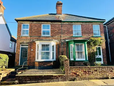 a brick house with a green door on a street at Spacious 3 bedroom house in Central Leiston in Leiston