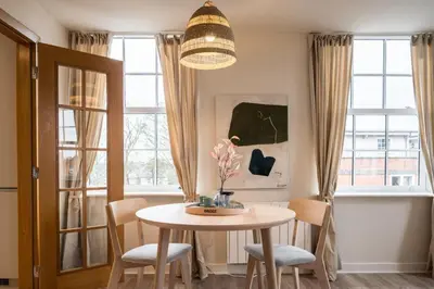 a table and chairs in a room with windows at Luxury Leiston 2 bed 2 bath with parking in Leiston
