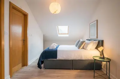 a bedroom with a bed and a table with a lamp at Luxury Leiston 2 bed 2 bath with parking in Leiston
