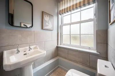 a bathroom with a sink and a toilet and a window at Luxury Leiston 2 bed 2 bath with parking in Leiston
