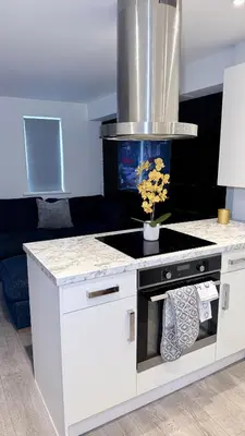 a kitchen with a white island with a stove at Private Kingsize Bedroom in Horndon on the Hill