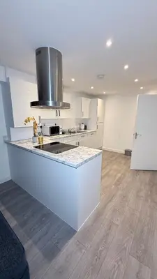 a white kitchen with a counter and a stove top oven at Private Kingsize Bedroom in Horndon on the Hill