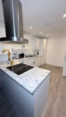 a white kitchen with a sink and a stove at Private Kingsize Bedroom in Horndon on the Hill