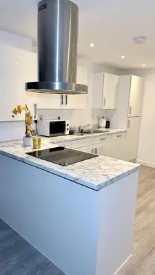 a kitchen with white cabinets and a counter top at Private Kingsize Bedroom in Horndon on the Hill