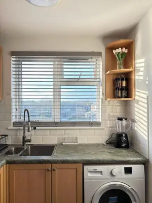 a kitchen with a sink and a washing machine at Cosy one bed Flat in Stevenage in Stevenage