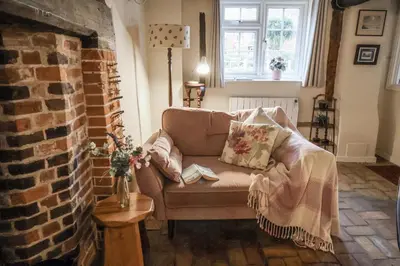 a living room with a couch and a brick wall at The Old Post Box in Holton