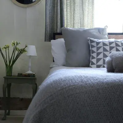 a bedroom with a bed and a table with a lamp at The Old Post Box in Holton