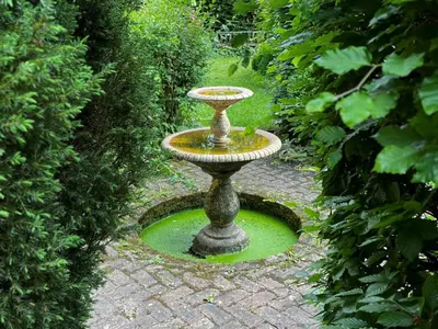 a bird bath sitting on a brick path in a garden at 1 Bed in Eye- oc-34390 in Thornham Magna