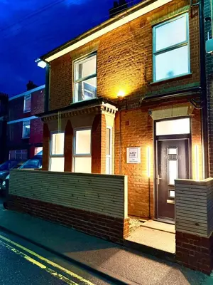 a brick house with a gate in front of it at Sleep Hub in Leiston