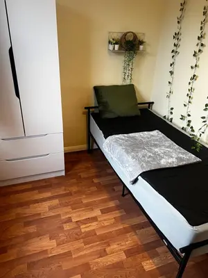 a bed in a room with a wooden floor at Single Room in town house in Rochford