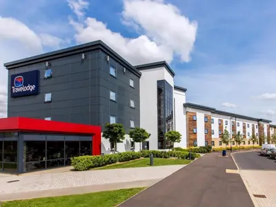 a large building with a sign on the front of it at Travelodge Cambridge Orchard Park in Milton