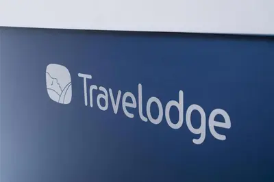 a sign for a travel loadage company on a wall at Travelodge Cambridge Orchard Park in Milton