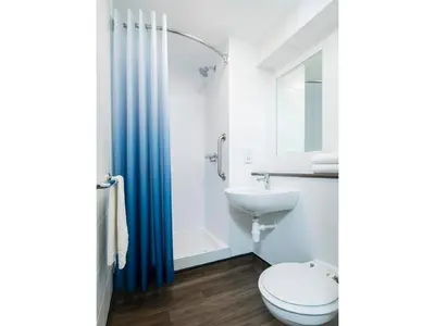 a bathroom with a toilet and a sink at Travelodge Cambridge Orchard Park in Milton