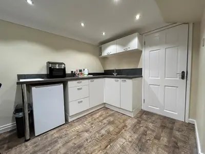 a kitchen with white cabinets and a white door at The old greengrocers Battlesbridge in Rawreth