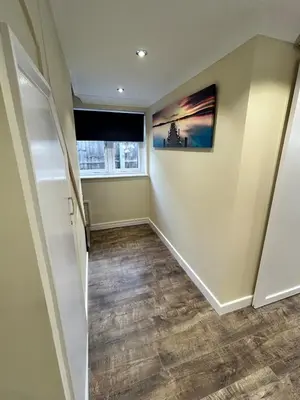 a hallway of a home with a staircase and a window at The old greengrocers Battlesbridge in Rawreth