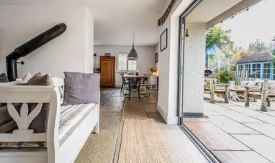 a living room with a patio with a table at Blackshore House in Wenhaston