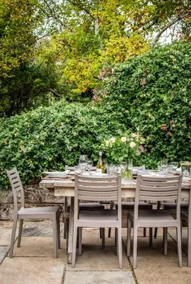 a wooden table with chairs and wine glasses on it at Blackshore House in Wenhaston